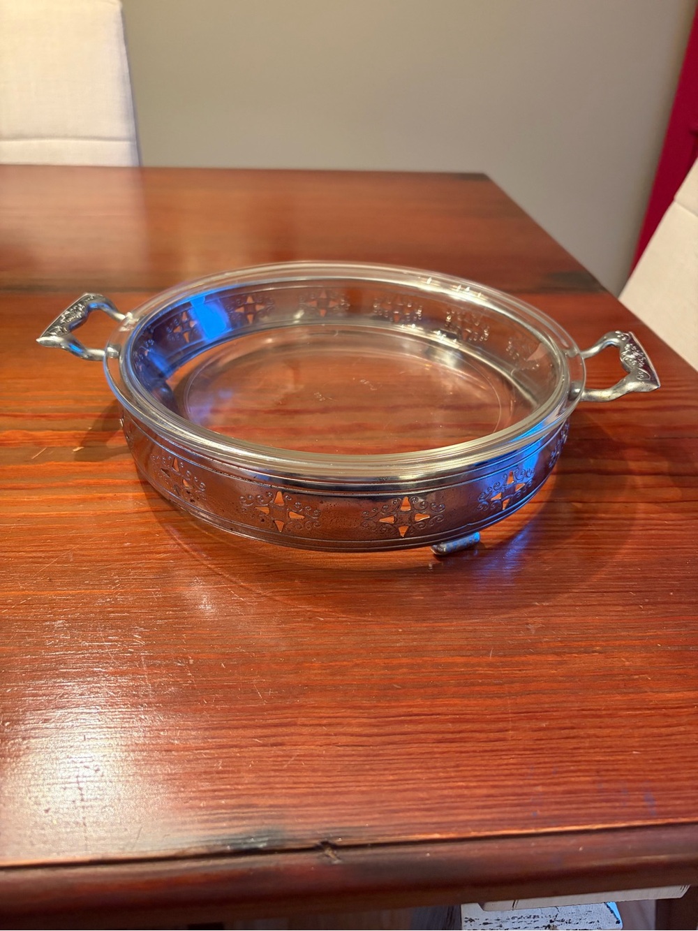 Vintage Pyrex clear glass casserole dish nestled in a chrome plated footed servi